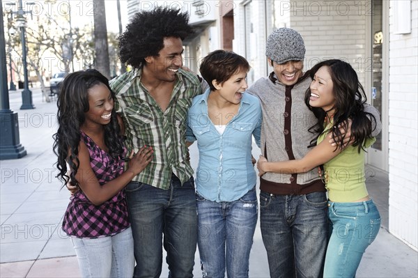 Smiling friends standing together hugging