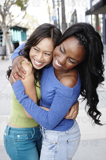 Smiling friends standing together hugging