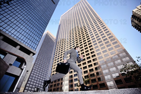 Businessman running past highrise building