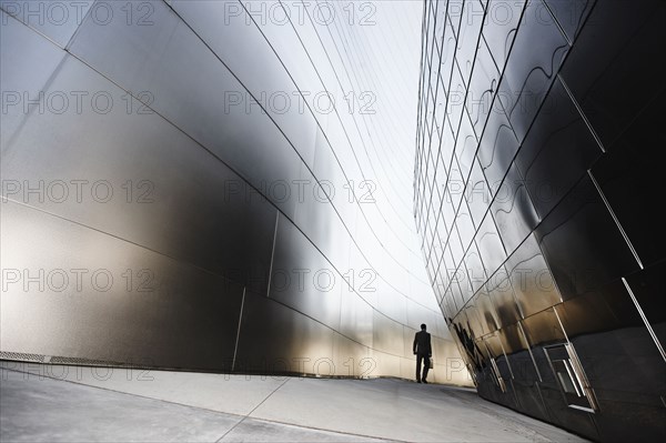 Businessman walking in urban alley