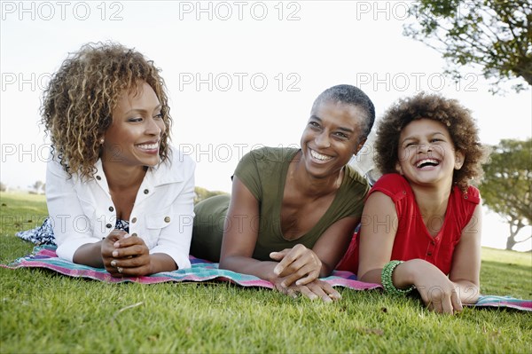 African American family laying on grass in park