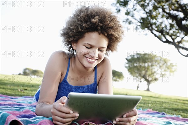 Girl using digital tablet in park