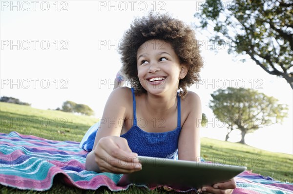 Girl using digital tablet in park