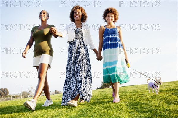 African American family walking dog in park