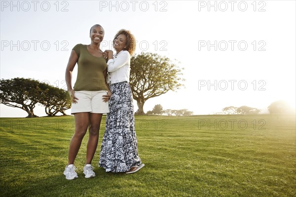 African American mother and daughter standing in park