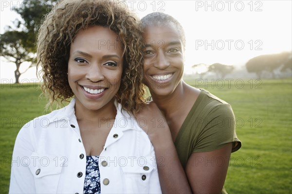 African American mother and daughter standing in park