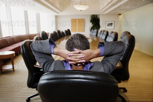 Black businesswoman sitting in empty conference room