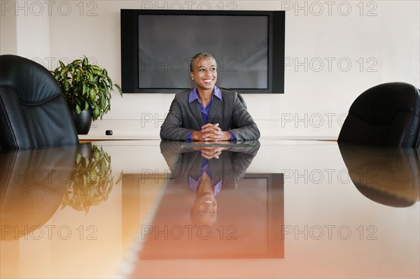 Black businesswoman sitting in empty conference room