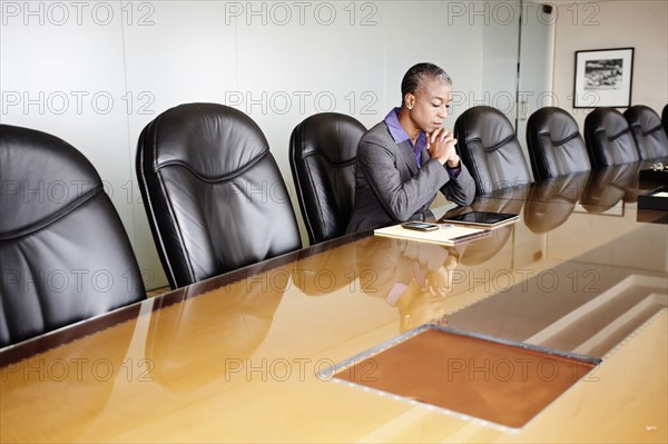 Black businesswoman sitting in empty conference room