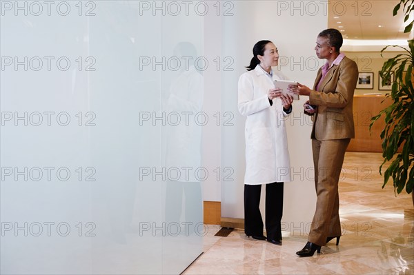 Doctor and businesswoman using digital tablet