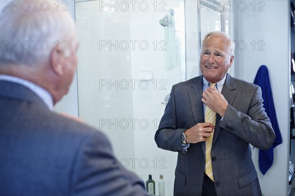 Caucasian man dressing in bathroom