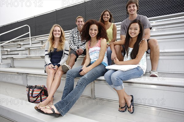 School friends sitting together on bleachers