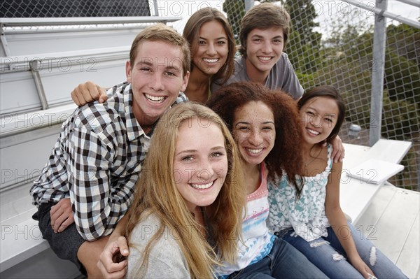 School friends sitting together on bleachers