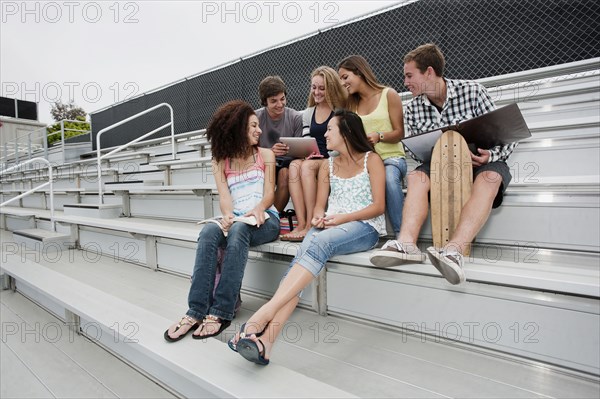 School friends sitting together on bleachers