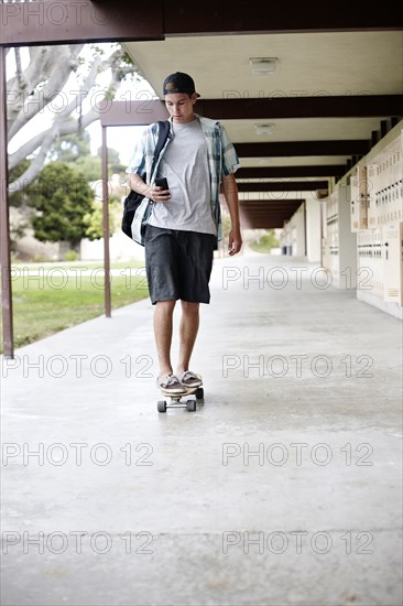 Caucasian teenager riding skateboard