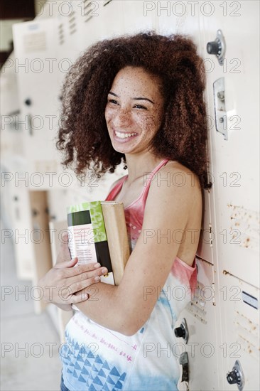 Mixed race woman leaning on school lockers