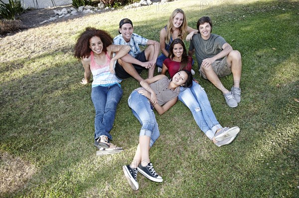 School friends sitting together in grass