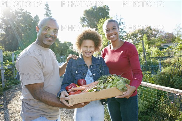 Family gathering vegetables in community garden