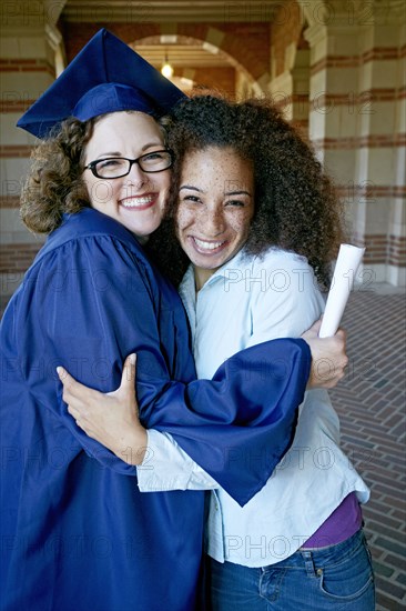 Friend hugging graduate