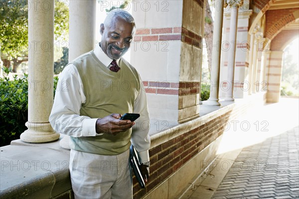 Black professor text messaging on cell phone