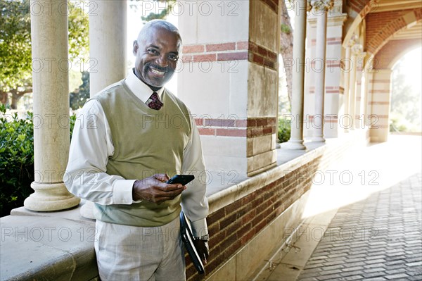 Black professor text messaging on cell phone