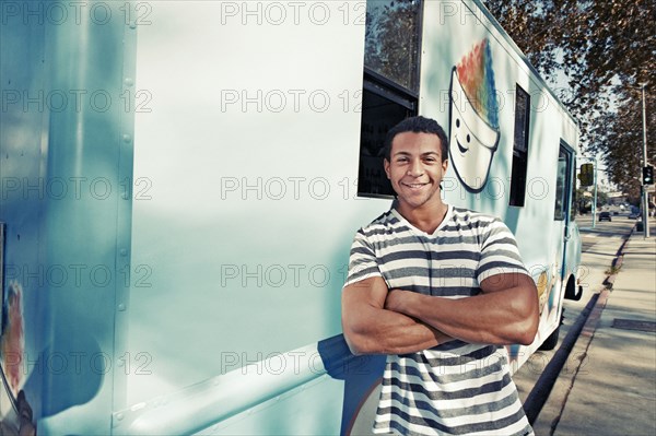 Mixed race man leaning on ice cream truck