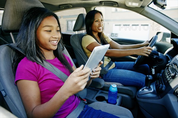 Girl using digital tablet in car