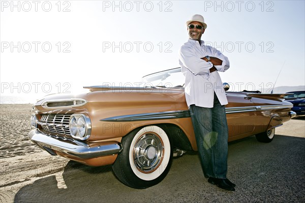 Black man leaning on convertible