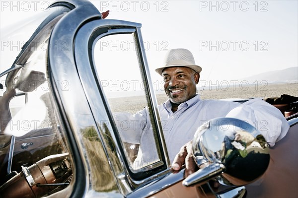 Black man driving convertible