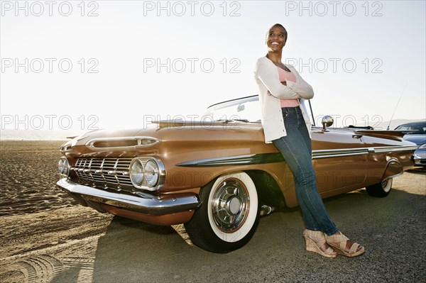 Black woman leaning on convertible