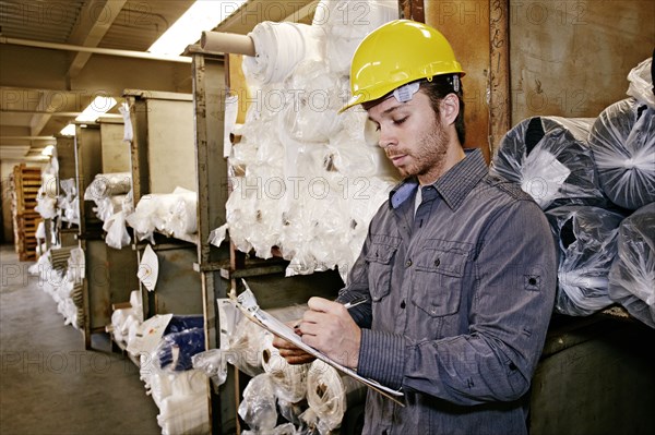 Caucasian worker checking product in warehouse