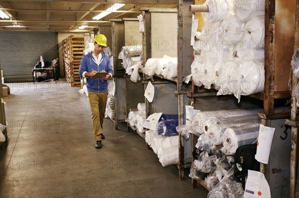 Caucasian worker checking product in warehouse