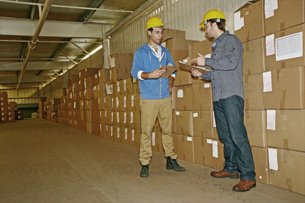 Caucasian workers talking in warehouse