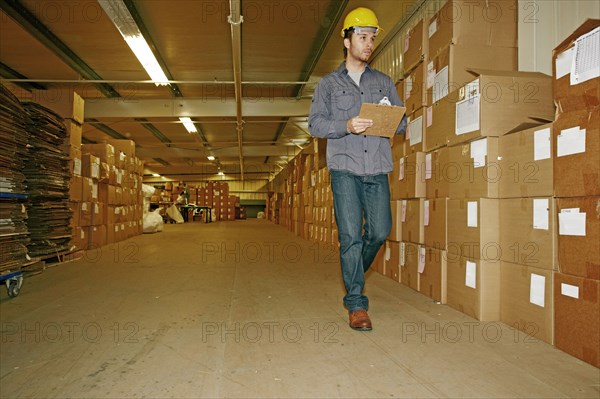 Caucasian worker checking product in warehouse