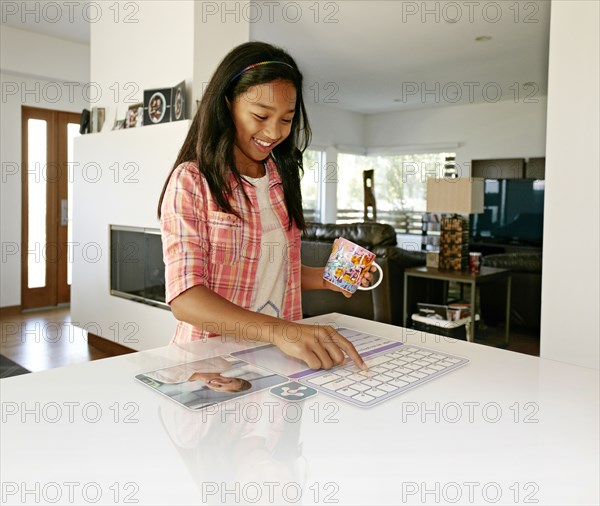 Mixed race girl using computer in table