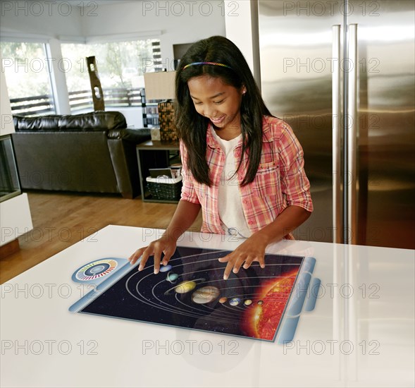 Mixed race girl playing on computer in table