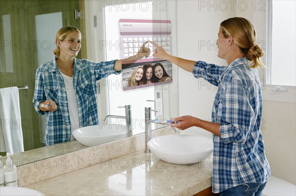 Woman using computer in mirror