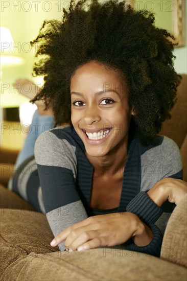 Mixed race woman relaxing on sofa