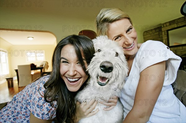 Women petting dog in kitchen