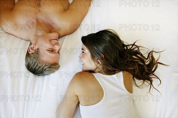 Caucasian couple relaxing on bed