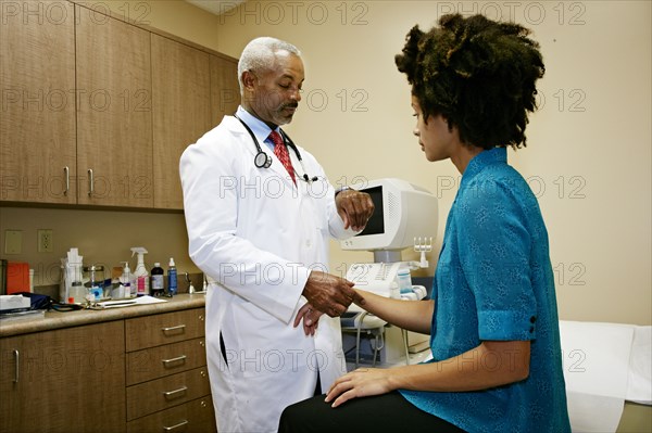 Doctor checking patient's pulse in office