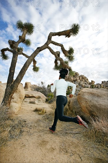 Black runner in desert landscape