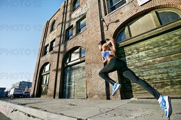 Black woman running on city street