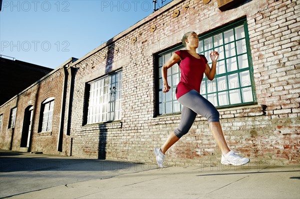 Black woman running on city street