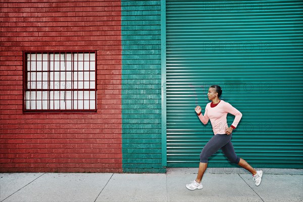 Black woman running on city street