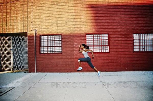 Black woman running on city street