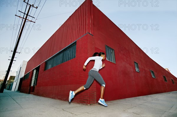 Black woman running on city street