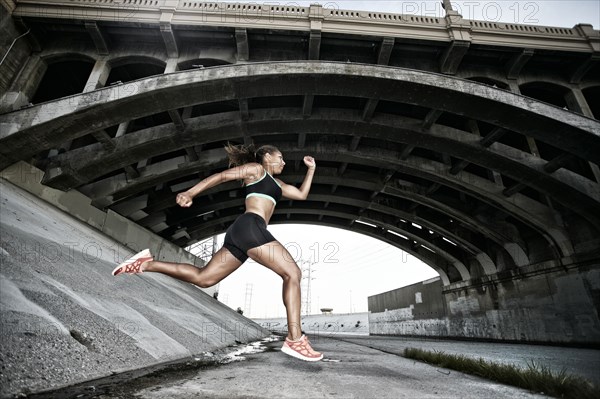 African American runner under overpass