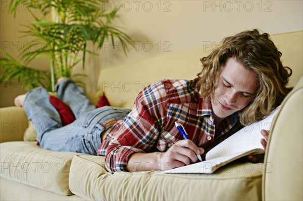 Caucasian man drawing on sofa