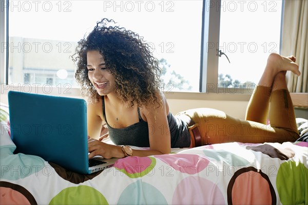 Mixed race college student using laptop in dorm